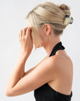 Woman with straight, blonde hair styled in a twist updo with a France Luxe small, Black & White claw hair clip.