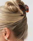 Woman with straight, blonde hair styled in an updo with a France Luxe small claw hair clip, rich amber and mahogany brown.