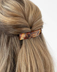 France Luxe medium French barrette for women pictured holding straight, blonde hair in a braided hairstyle.