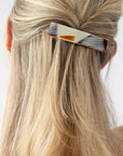 France Luxe medium, brown barrette for women pictured holding straight, blonde hair in a half up hairstyle.