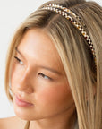 France Luxe checkered tortoise and ivory headband for women pictured holding straight, blonde hair in a loose hairstyle.