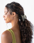 Silver Claw Hair Clip pictured in pulled back, brown, curly hair. Hair accessory made in France by France Luxe.