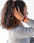 L. Erickson holiday themed, no damage hair ties, styling dark brown, voluminous, curly, high ponytail with festive hair tie bracelets.