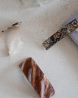 Classic French barrettes in multiple sizes for fine to thick hair, pictured on a counter.
