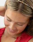 France Luxe thin headband in a marbled gray and charcoal color, pictured holding straight, blonde hair in a loose hairstyle.