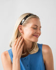France Luxe Tortoise Shell headband for women pictured holding straight, blonde hair in a loose hairstyle.