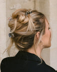 France Luxe Grey Mini Claw Hair Clip holding straight, blonde hair back in a loose bun.