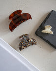 Several elegant Mini Couture French Hair Clips by France Luxe pictured on side table.