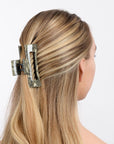 large hair clip with a cutout design holding hair up in a half up half down hair style