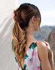 large claw hair clip holding hair at the back of the head