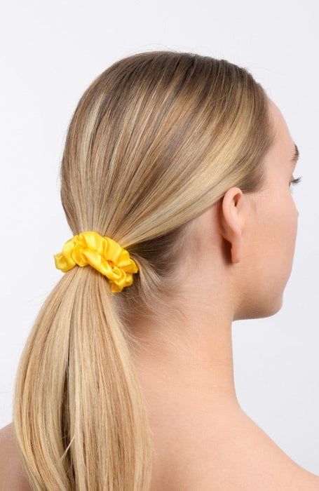 Bright yellow silk scrunchie in blonde hair.