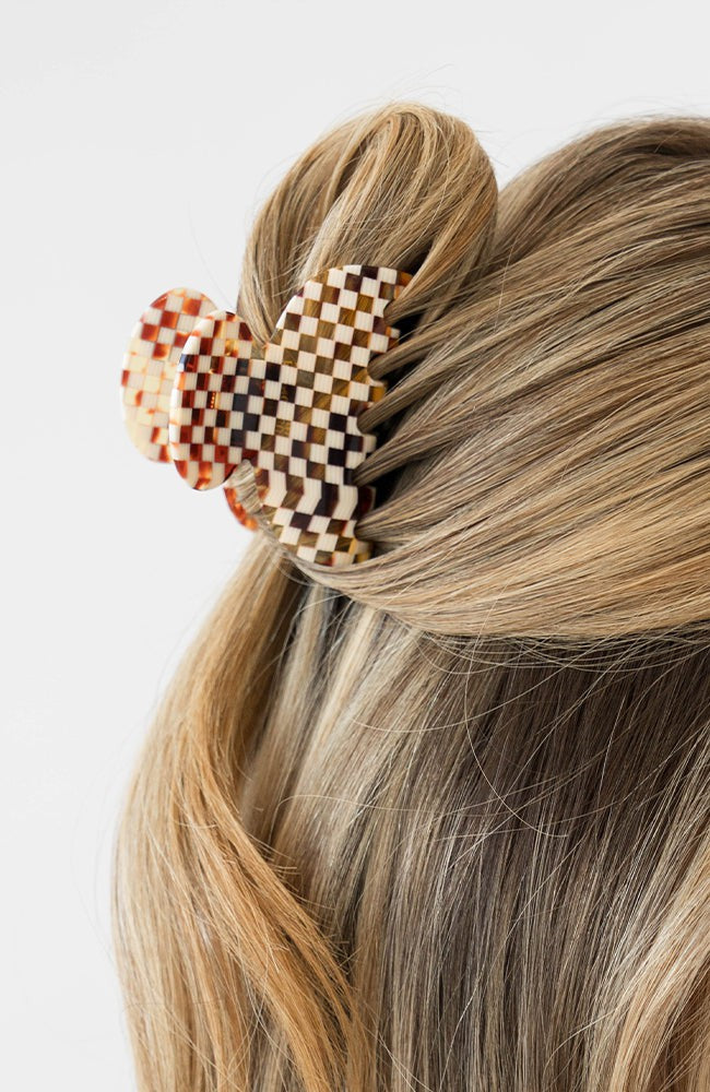 France Luxe small French claw hair clip for women pictured holding straight, blonde hair in a half up hairstyle.