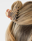 France Luxe small French claw hair clip for women pictured holding straight, blonde hair in a half up hairstyle.