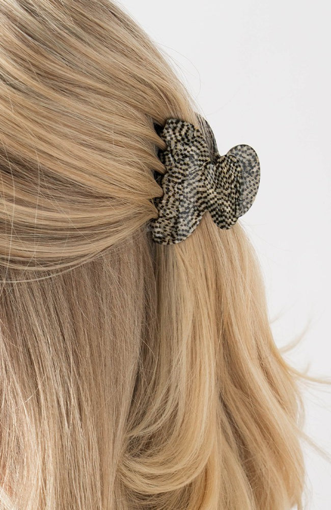 France Luxe small French claw hair clip for women pictured holding straight, blonde hair in a half up hairstyle.