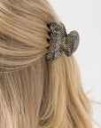 France Luxe small French claw hair clip for women pictured holding straight, blonde hair in a half up hairstyle.