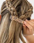 France Luxe medium French barrette for women pictured holding straight, blonde hair in a braided hairstyle.