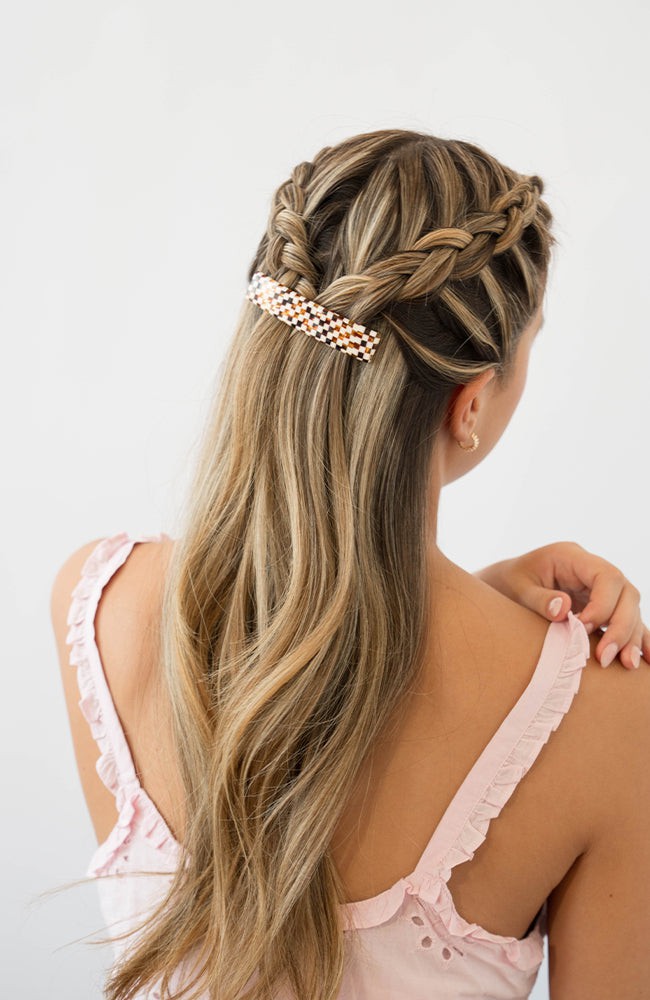 France Luxe medium French barrette for women pictured holding straight, blonde hair in a braided hairstyle.