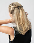 France Luxe medium French barrette for women pictured holding straight, blonde hair in a braided hairstyle.