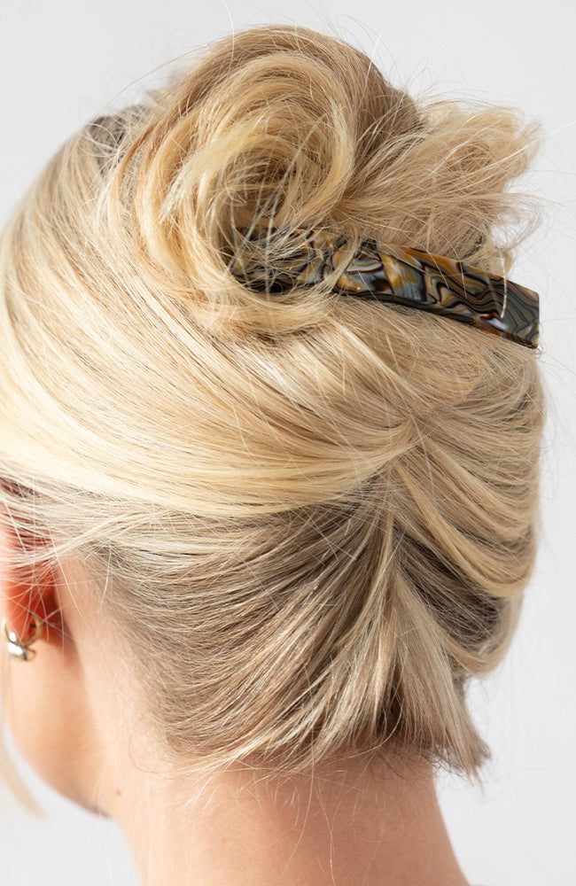 Woman with straight, blonde hair styled in a twist updo with a France Luxe medium, Grey barrette.
