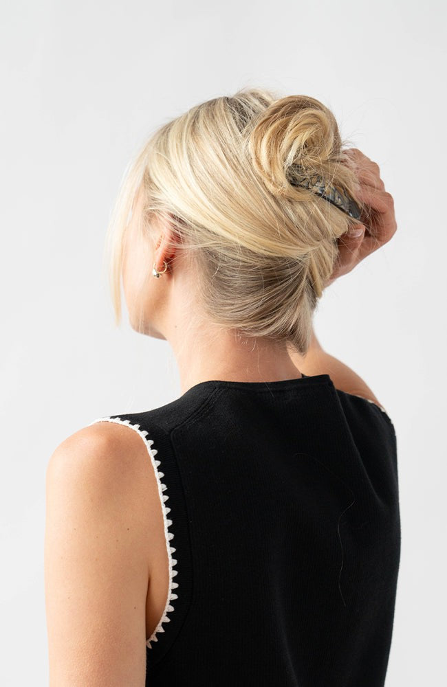 Woman with straight, blonde hair styled in an updo with a France Luxe medium barrette, marbled gray and charcoal.