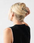 Woman with straight, blonde hair styled in an updo with a France Luxe medium barrette, marbled gray and charcoal.