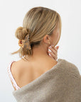Woman with straight, blonde hair styled in an updo with a France Luxe medium claw hair clip, checkered tortoise and ivory.