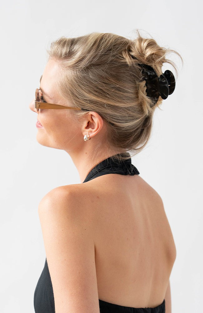 Woman with straight, blonde hair styled in an updo with a France Luxe medium claw hair clip, marbled pearlescent black.