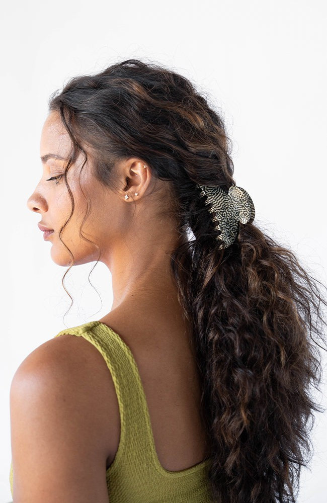 Silver Claw Hair Clip pictured in pulled back, brown, curly hair. Hair accessory made in France by France Luxe.