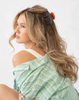 France Luxe medium French claw hair clip for women pictured holding straight, blonde hair in a half up hairstyle.