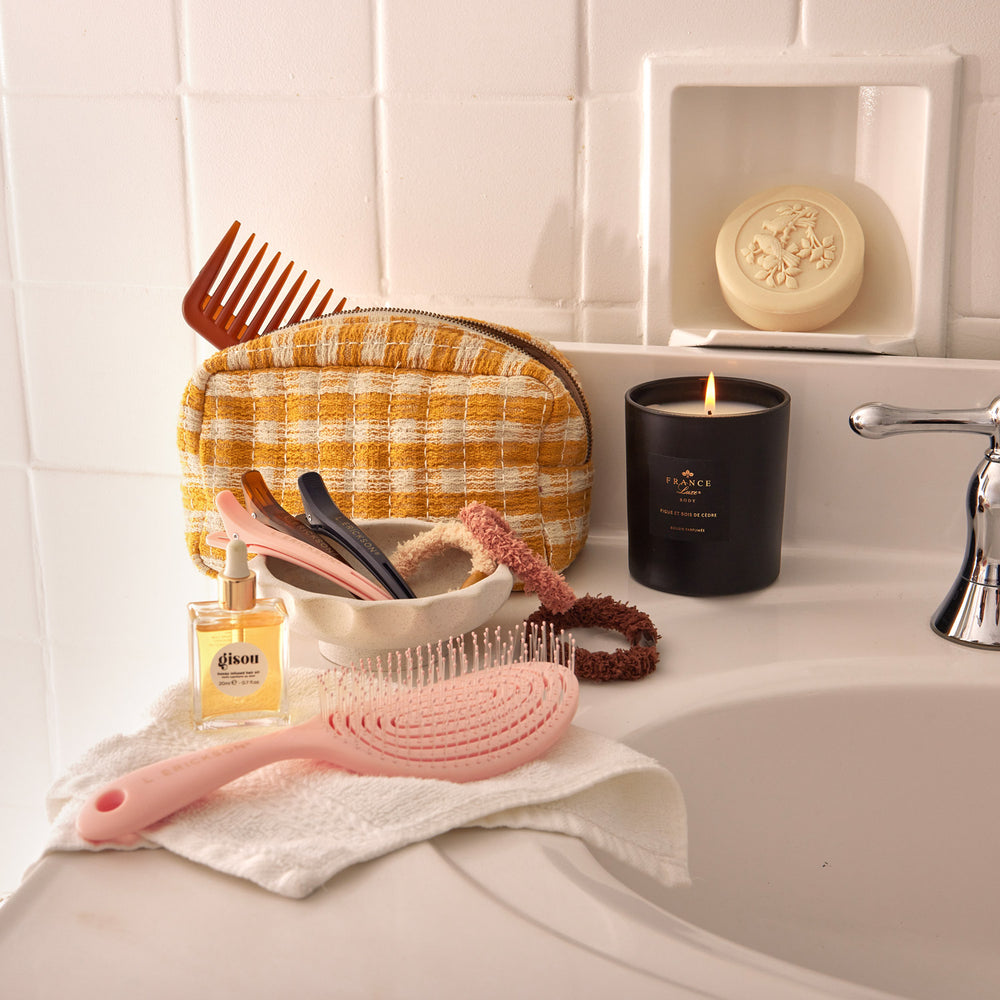 Essentials for your bath for a luxurious morning routine include detangler comb, vent nylon bristle brush, hair pinch clips, cozy soft ponytail holders, and scented French soap and candle