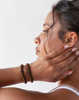 L. Erickson hair ties for thick hair, styling dark brown, curly, hair tie bracelets on wrist.