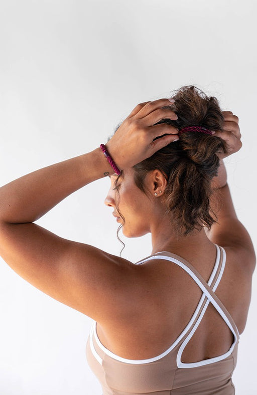 Woman using Purple L. Erickson hair ties for thick hair. Strong and gentle. Damage free, crease free.