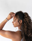Black hair ties styling a curly, half up ponytail. L. Erickson Grab & Go Pony, Black Metallic Pack.