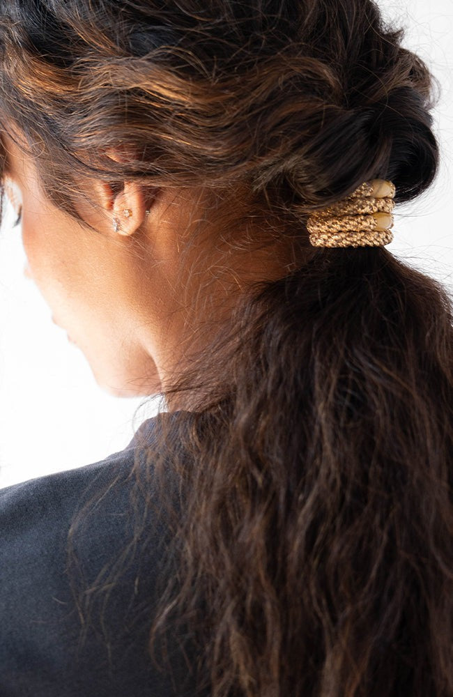 Gold hair ties styling a voluminous, curly  low ponytail. L. Erickson Grab &amp; Go Pony, Cotton Candy.