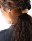 Gold hair ties styling a voluminous, curly  low ponytail. L. Erickson Grab & Go Pony, Cotton Candy.