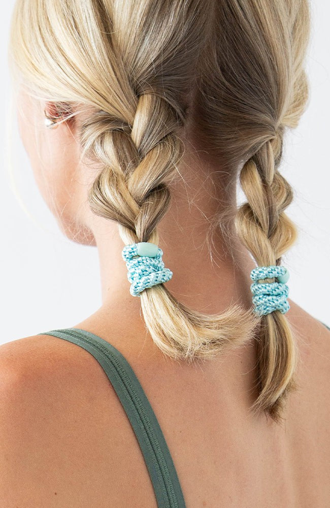 Thick hair ties with style. Woman using L. Erickson ponytail holders in her braided pigtails.