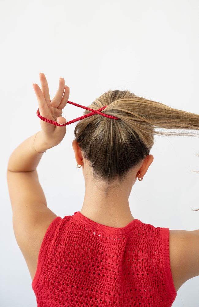 Woman using red L. Erickson hair ties for fine hair. Strong and gentle. Damage free, crease free.