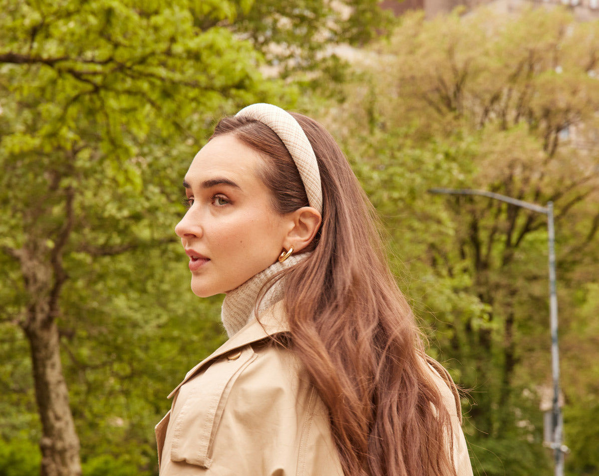 Fall outfit features a cream weave headband with matching sweater and trench coat.