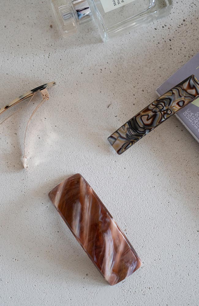 Classic French barrettes in multiple sizes for fine to thick hair, pictured on a counter.