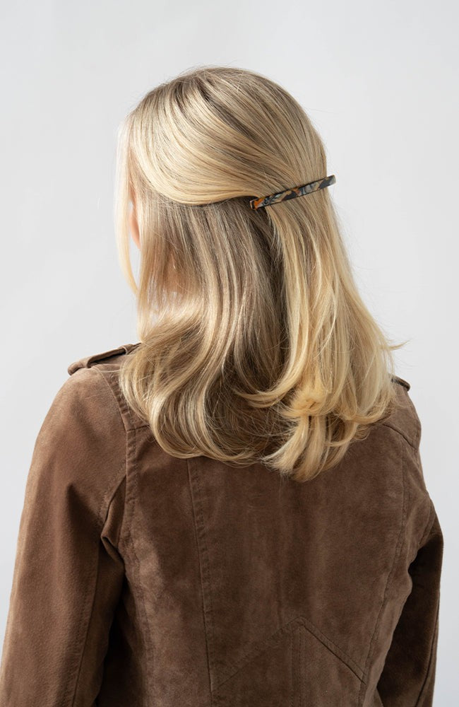 France Luxe long French barrette for women pictured holding straight, blonde hair in a half up hairstyle.