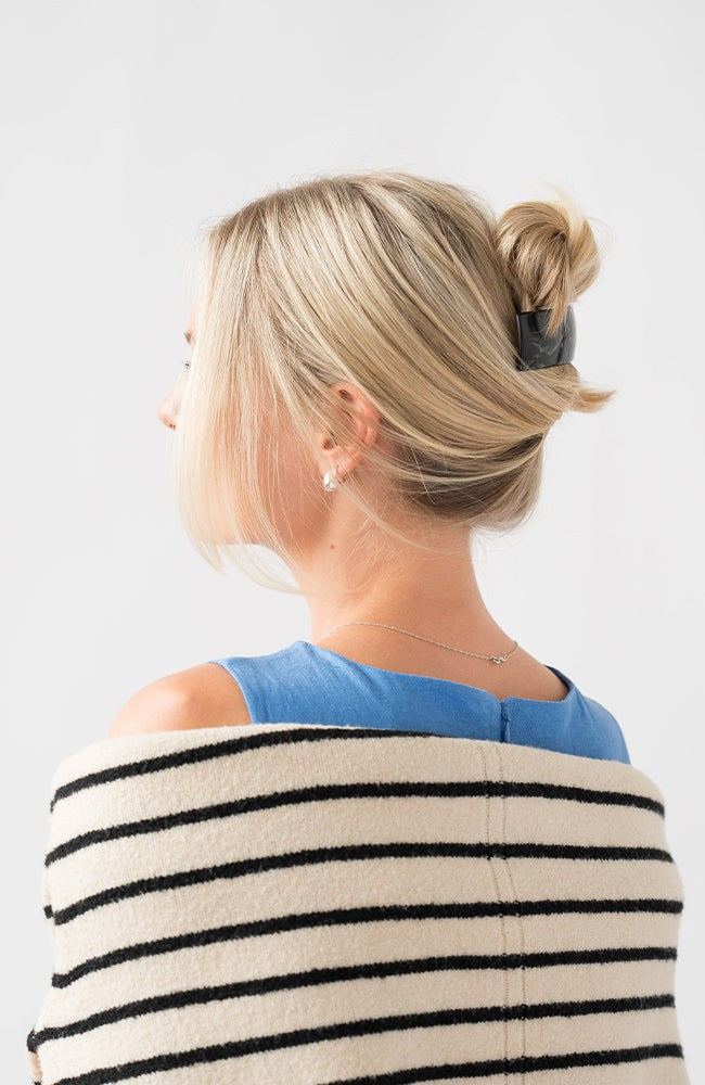 Woman with straight, blonde hair styled in a twist updo with a France Luxe large, Black barrette.