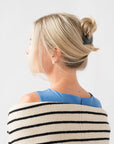 Woman with straight, blonde hair styled in a twist updo with a France Luxe large, Black barrette.