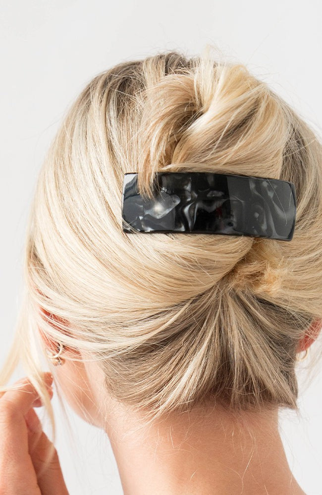 Woman with straight, blonde hair styled in a twist updo with a France Luxe large, Black barrette.