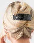 Woman with straight, blonde hair styled in a twist updo with a France Luxe large, Black barrette.