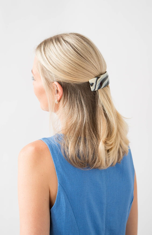 France Luxe large French barrette for women pictured holding straight, blonde hair in a half up hairstyle.