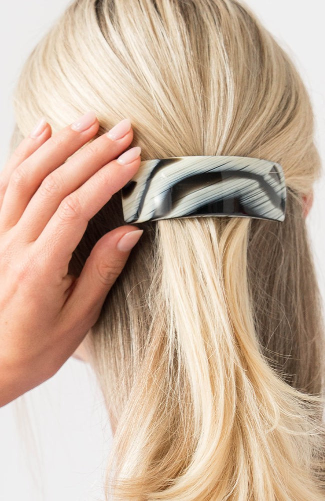 France Luxe large French barrette for women pictured holding straight, blonde hair in a half up hairstyle.