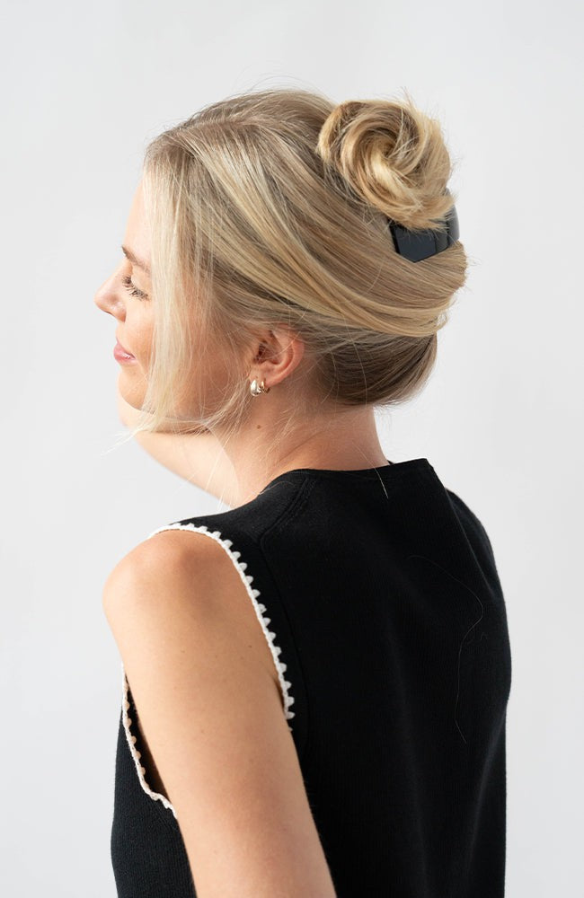 Woman with straight, blonde hair styled in a twist updo with a France Luxe large, Black barrette.