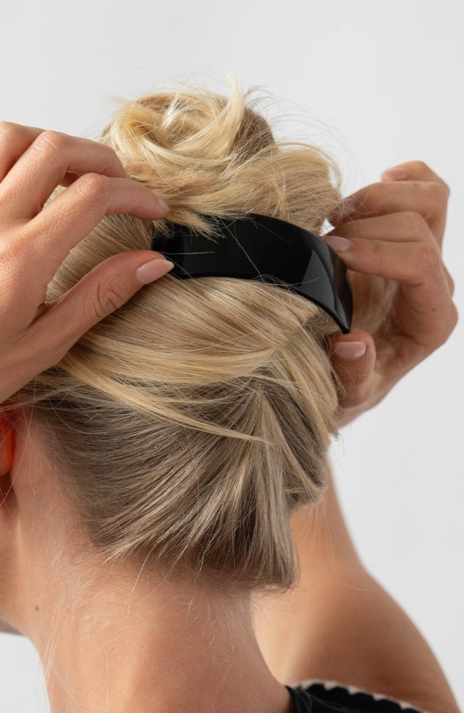 Woman with straight, blonde hair styled in a twist updo with a France Luxe large, Black barrette.