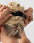 Woman with straight, blonde hair styled in a twist updo with a France Luxe large, Black barrette.