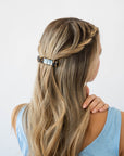 France Luxe medium French barrette for women pictured holding straight, blonde hair in a braided hairstyle.